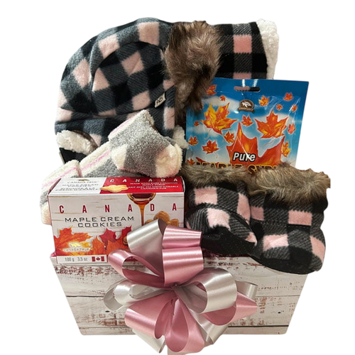 Canadian Girl gift basket with cozy plaid slippers and hat, maple cream cookies, maple syrup, and a large decorative pink and white bow, offered by Cherished Gift Baskets for gourmet gift delivery Canada.