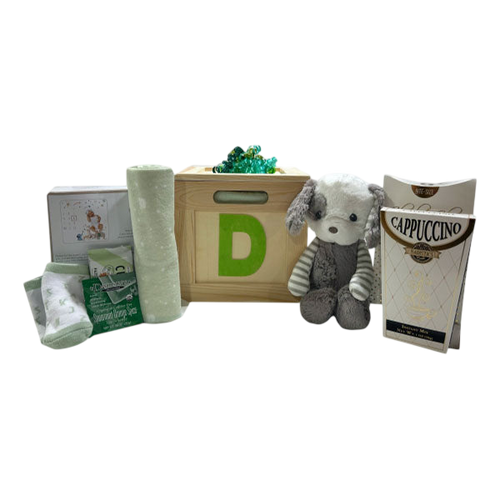 A cozy gift set featuring soft baby socks, a plush toy dog, a wooden block with the letter D, and a cappuccino mix, thoughtfully arranged as Baby Things by Cherished Gift Baskets.