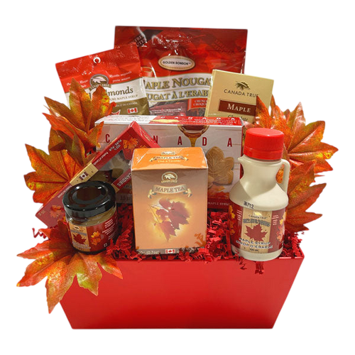 Canadian Gift Box featuring gourmet Canadian treats including maple syrup, maple tea, maple nougat, and chocolates, beautifully arranged in a red basket with autumn leaves from Cherished Gift Baskets.